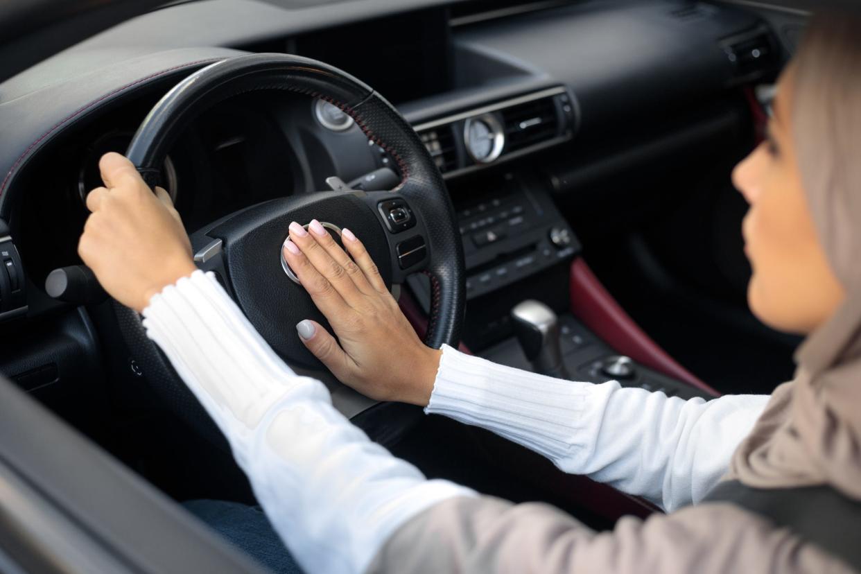 A woman honking a car horn.