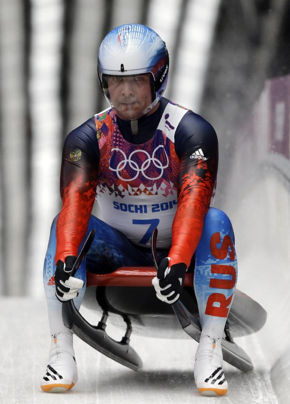 Albert Demchenko of Russia brakes in the finish area after his second run during the men's singles luge competition at the 2014 Winter Olympics, Saturday, Feb. 8, 2014, in Krasnaya Polyana, Russia. (AP Photo/Dita Alangkara)