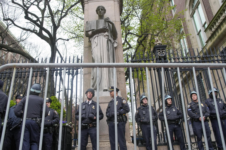 New York City police in riot gear stand guard outside the Columbia University campus after clearing the campus of protesters, Thursday, April 18, 2024, in New York. The protesters were calling for the school to divest from corporations they claim profit from the war in the Middle East. (AP Photo/Mary Altaffer)