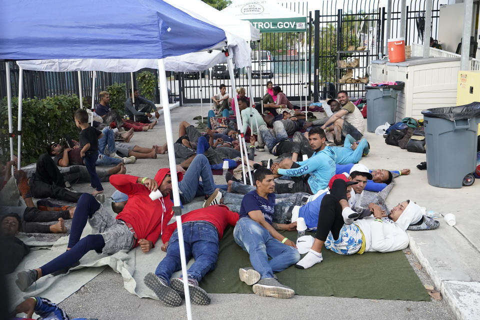 Recently arrived migrants wait in a garage area of the U.S. Customs and Border Protection - Marathon Border Patrol Station, Wednesday, Jan. 4, 2023, in Marathon, Fla. More than 500 Cuban immigrants have come ashore in the Florida Keys since the weekend, the latest in a large and increasing number who are fleeing the communist island. (AP Photo/Wilfredo Lee)