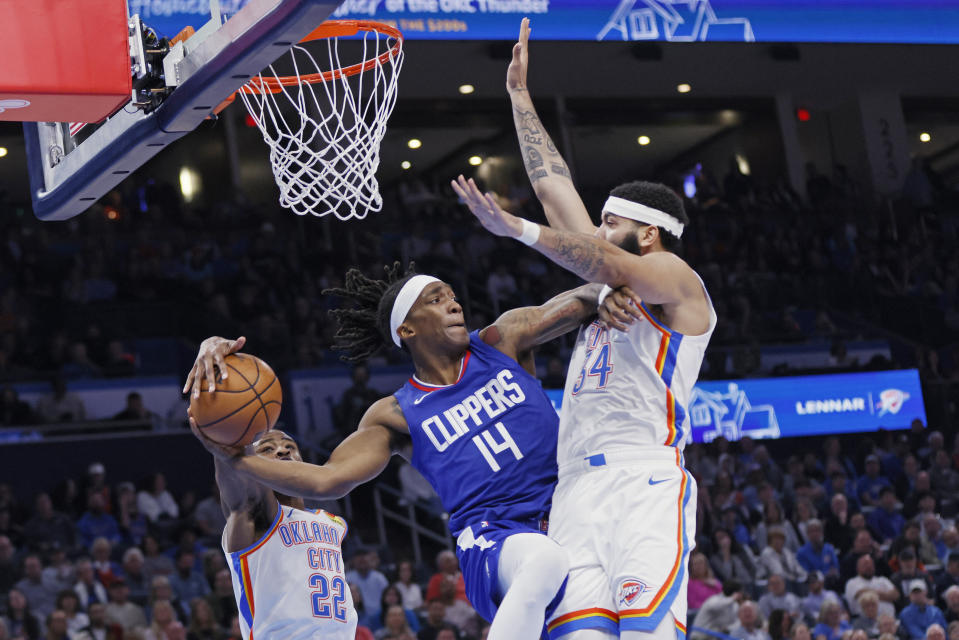 Oklahoma City Thunder guard Cason Wallace (22) steals the ball from Los Angeles Clippers guard Terance Mann (14) as Thunder forward Kenrich Williams (34) defends during the second half of an NBA basketball game, Thursday, Feb. 22, 2024, in Oklahoma City. (AP Photo/Nate Billings)