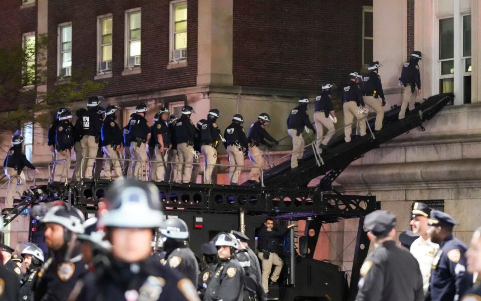 Police officers use a ramp on an armored vehicle to enter Hamilton Hall