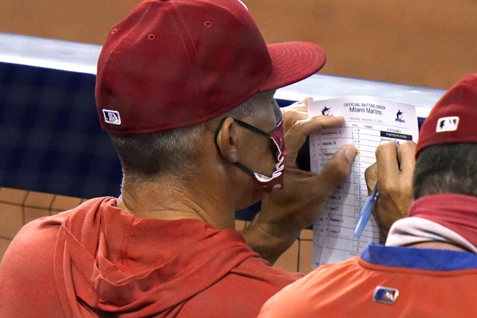 Philadelphia Phillies manager Joe Girardi looks at the lineup during the fourth inning of a baseball game against the Miami Marlins, Monday, Sept. 14, 2020, in Miami. (AP Photo/Lynne Sladky)