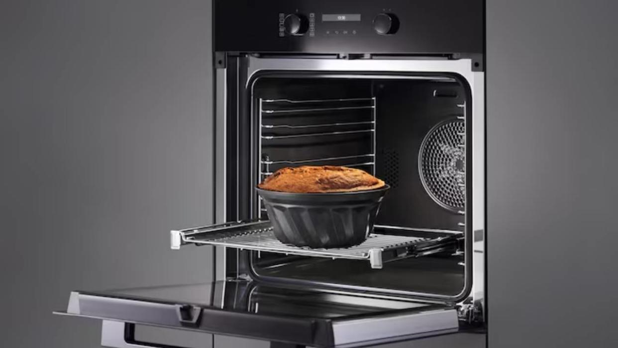  A lifestyle image of the Miele oven with an open door and a pie going in on a shelf. 