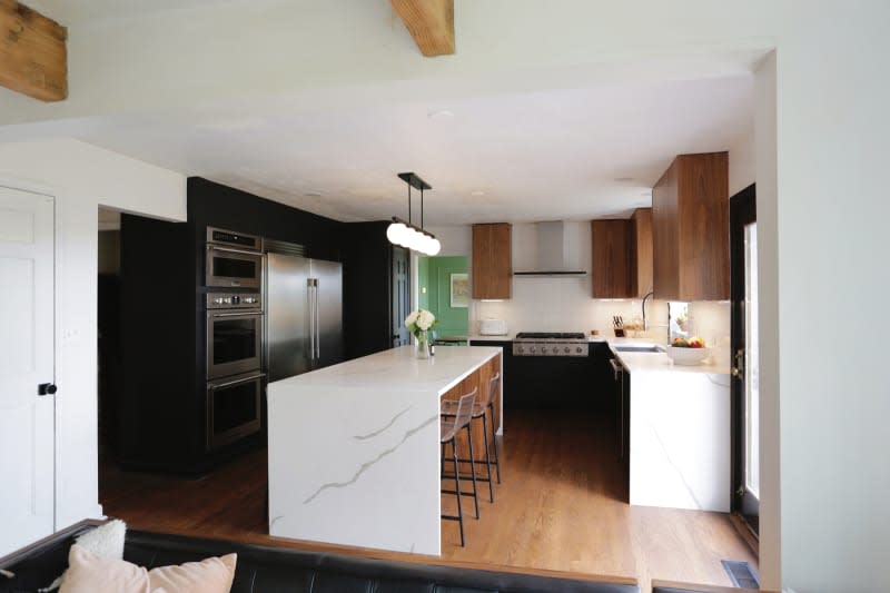 Waterfall island in black and white kitchen.