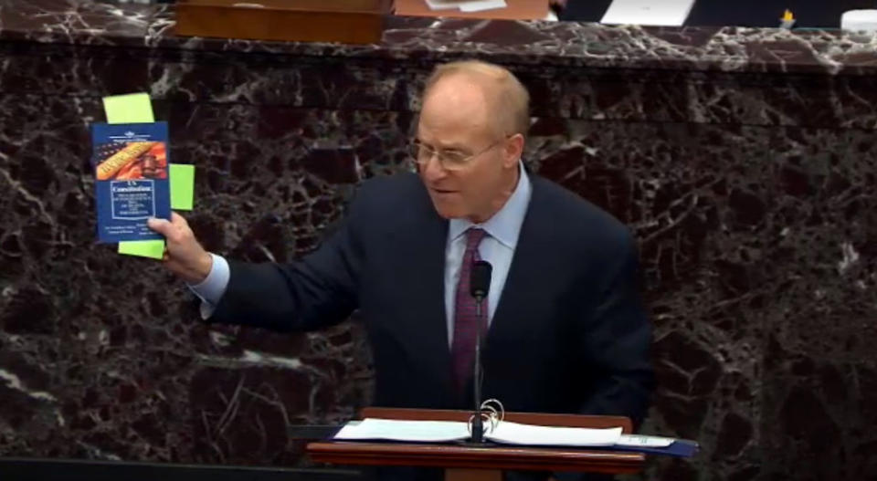 David Schoen, speaks while holding a copy of the Constitution. 