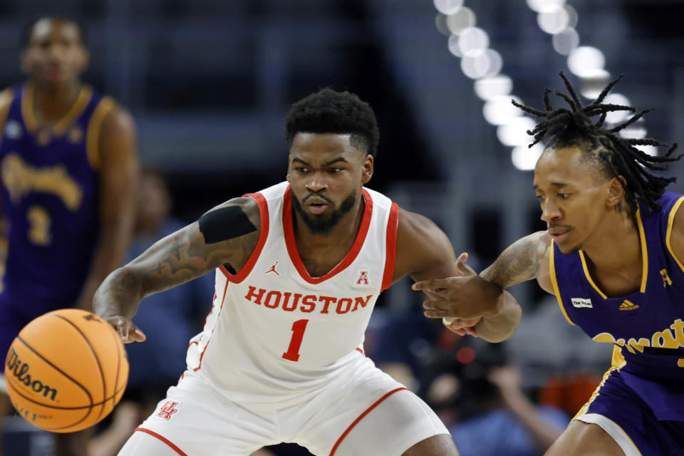 Houston guard Jamal Shead (1) steals the ball from East Carolina guard Jaden Walker during the first half of an NCAA college basketball game in the quarterfinals of the American Athletic Conference Tournament, Friday, March 10, 2023, in Fort Worth, Texas. (AP Photo/Ron Jenkins)