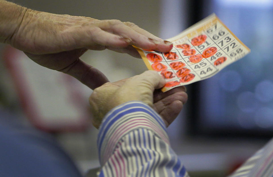 In this photo taken Tuesday, April 10, 2012, a completed Bingo card is handed to an attendant, left, during play in Bald Knob, Ark. (AP Photo/Danny Johnston)