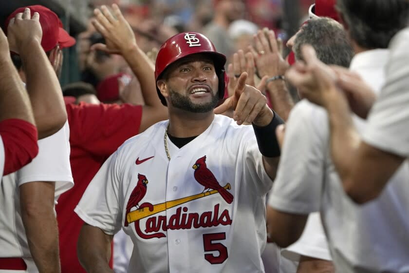 St. Louis Cardinals' Albert Pujols (5) is congratulated by teammates after scoring on a two-run home run.