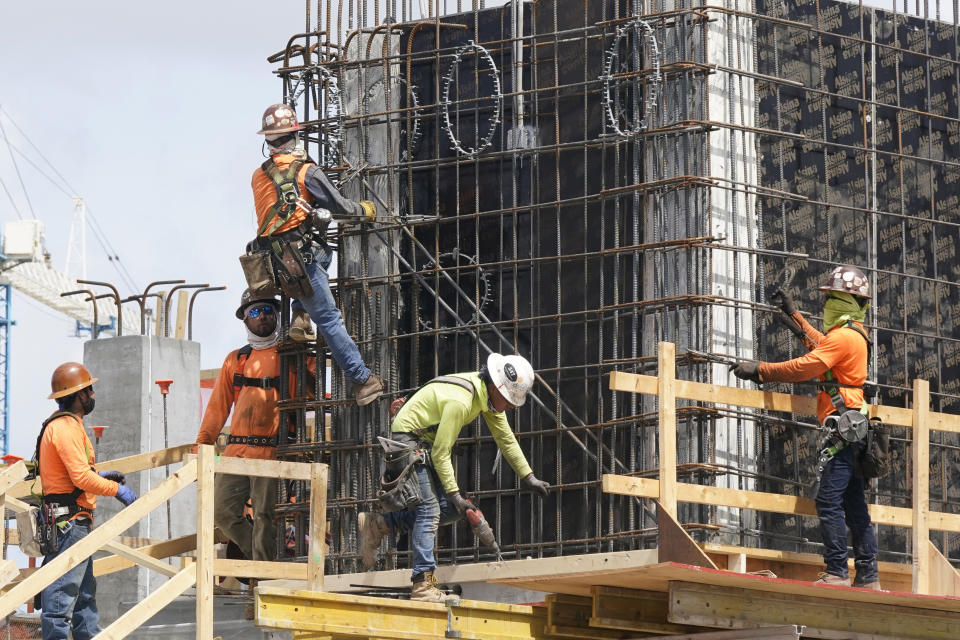 FILE - Construction workers fasten the frame of a new building, Monday, May 3, 2021, in Miami. The number of available jobs in the U.S. plummeted in August 2022 compared with July as businesses grow less desperate for workers, a trend that could cool chronically high inflation. (AP Photo/Marta Lavandier, File)