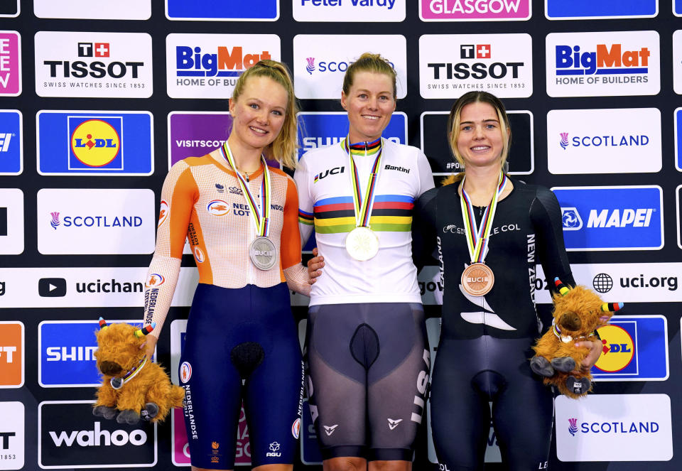 USA's Jennifer Valente, centre, celebrates on the podium after winning gold in the Women's Elite Scratch Race, alongside Netherlands' Maike van der Duin, left, who won silver and New Zealand's Michaela Drummond, who won bronze, during day two of the 2023 UCI Cycling World Championships at the Sir Chris Hoy Velodrome, Glasgow, Scotland, Friday, Aug. 4, 2023. (Tim Goode/PA via AP)