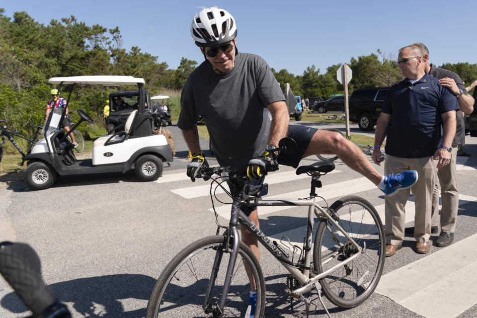 President Joe Biden gets back on his bike after he fell when he tried to get off his bike to greet a crowd at Gordons Pond in Rehoboth Beach, Del., Saturday, June 18, 2022. (AP Photo/Manuel Balce Ceneta)
