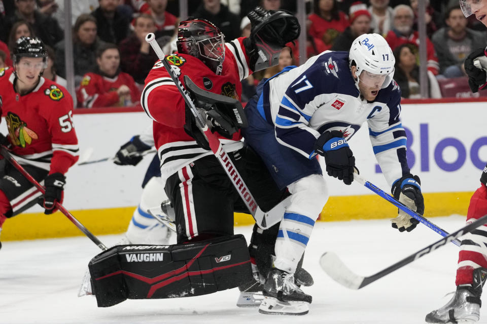 Winnipeg Jets center Adam Lowry, right, runs into Chicago Blackhawks goaltender Petr Mrazek, resulting in an interference call during the second period of an NHL hockey game Wednesday, Dec. 27, 2023, in Chicago. (AP Photo/Erin Hooley)