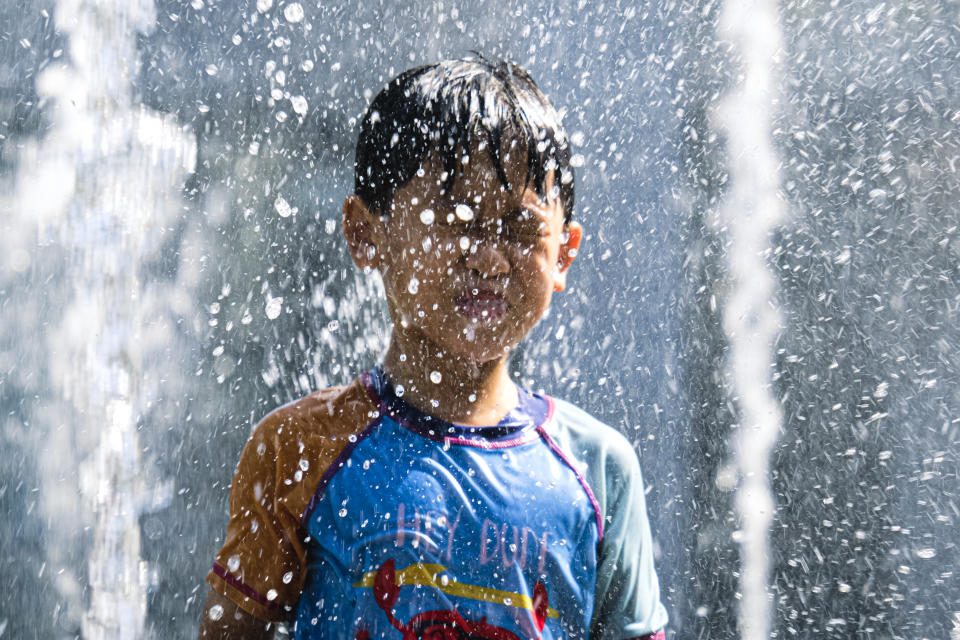 HONG KONG, CHINA - JULY 23: Kids play in front of the water fountain during a heat wave on July 23, 2022 in Hong Kong, China. Temperatures went above 36.6 C in Hong Kong this week. Observatory records nine consecutive 'very hot' days this month, the sixth-longest streak for Hong Kong since 1884. (Photo by Sawayasu Tsuji/Getty Images)