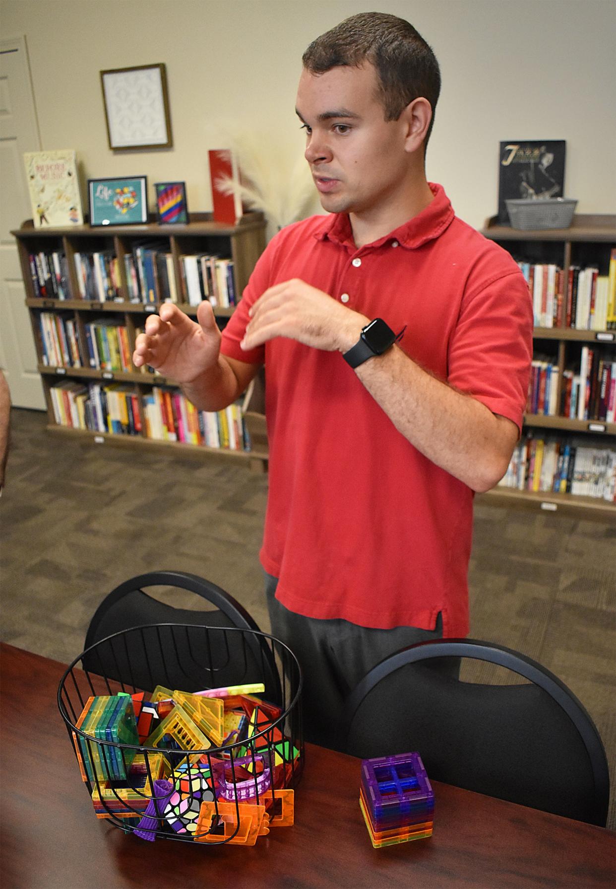 Sam Freitas talks about his design for the Infinity Library at People, Incorporated on Thursday, Aug. 8, 2024. The library is designed by and for neurodiverse people.