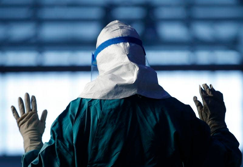 Barbara Smith, a registered nurse with Mount Sinai Medical Health Systems, St. Luke's and Roosevelt Hospitals in New York, demonstrates putting on personal protective equipment (PPE) during an Ebola educational session for healthcare workers at the Jacob Javits Convention center in New York, October 21, 2014. REUTERS/Mike Segar