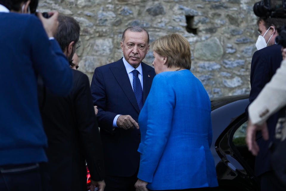 Turkey's President Recep Tayyip Erdogan, center, talks to German Chancellor Angela Merkel at the end of their meeting at Huber Villa presidential palace, in Istanbul, Turkey, Saturday, Oct. 16, 2021. The leaders discussed Ankara's relationship with Germany and the European Union as well as regional issues including Syria and Afghanistan. (AP Photo/Francisco Seco)