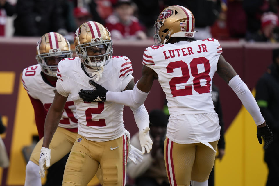 San Francisco 49ers cornerback Deommodore Lenoir (2) celebrating his interception with teammate cornerback Darrell Luter Jr. (28) during the second half of an NFL football game against the Washington Commanders, Sunday, Dec. 31, 2023, in Landover, Md. (AP Photo/Alex Brandon)