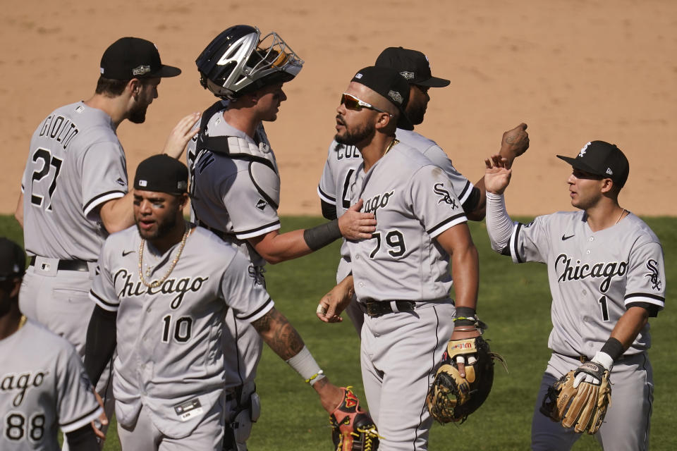 Chicago White Sox's Lucas Giolito, clockwise from top left, celebrates with James McCann, Jose Abreu, Alex Colome, Nick Madrigal and Yoan Moncada (10) after the White Sox defeated the Oakland Athletics in Game 1 of an American League wild-card baseball series Tuesday, Sept. 29, 2020, in Oakland, Calif. (AP Photo/Eric Risberg)