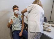 In this photo released by Spanish Soccer Federation (RFEF), Spain's Marcos Llorente receives a COVID-19 vaccine shot at Las Rozas Sports City in Madrid, Spain, Friday, June 11, 2021. Worried that a coronavirus outbreak could derail its chances at the European Championship, Spain sent in the army on Friday to vaccinate the national soccer team three days before its opening match at the tournament. Medics from Spain's Armed Forces administered the shots at the team's training facility near Madrid. (Pablo Garcia/RFEF via AP)
