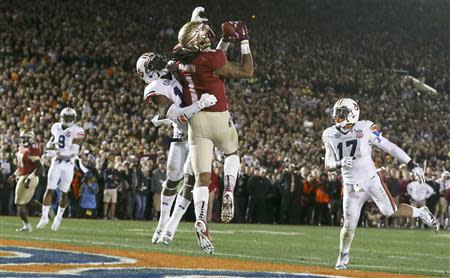 Florida State Seminoles Kelvin Benjamin (2ndR) catches the game winning touchdown pass while being covered by Auburn Tigers Chris Davis (2nd L) and Kris Frost (R) in the fourth quarter during the BCS Championship football game in Pasadena, California January 6, 2014. REUTERS/Lucy Nicholson