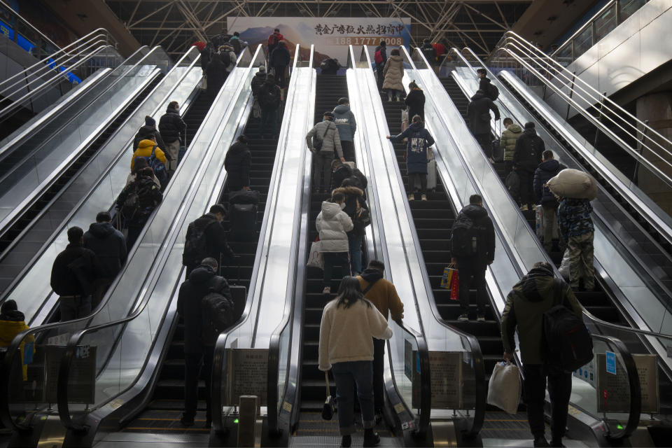 Travelers ride escalators at Beijing West Railway Station in Beijing, Wednesday, Jan. 18, 2023. China in December lifted its strict "zero-COVID" policy, letting loose a wave of pent-up travel desire, particularly around China's most important time for family gatherings, referred to in China as the Spring Festival, that may be the only time in the year when urban workers return to their hometowns. (AP Photo/Mark Schiefelbein)