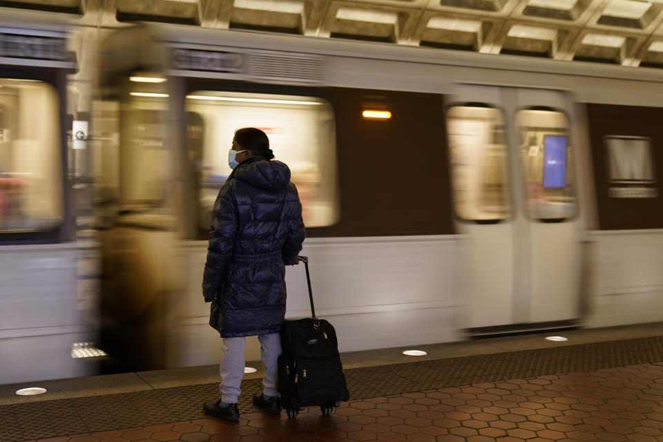A woman waits to board a train as it arrives at Metro Center station, Friday, April 23, 2021, in Washington. As President Joe Biden urges more federal spending for public transportation, transit agencies decimated by COVID-19 are struggling with a new uncertainty: how to win passengers back. (AP Photo/Patrick Semansky)