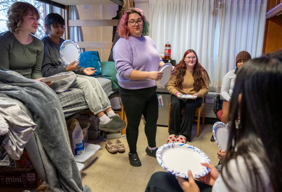 Abigail Turner (middle), hands out plates on Wednesday, Jan. 31, 2024, at Turner’s dorm room on the University of Indianapolis campus. The college friends are having a regular hangout, and are about to share a pizza. Turner has Retinitis pigmentosa, a rare disease that contracts her vision to a small spot at the center of her vision.