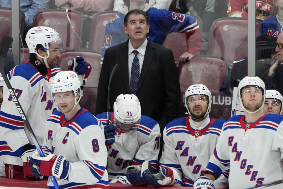 New York Rangers Peter Laviolette, top center, watches a replay review in the third period of an NHL hockey game against the Florida Panthers, Friday, Dec. 29, 2023, in Sunrise, Fla. (AP Photo/Lynne Sladky)