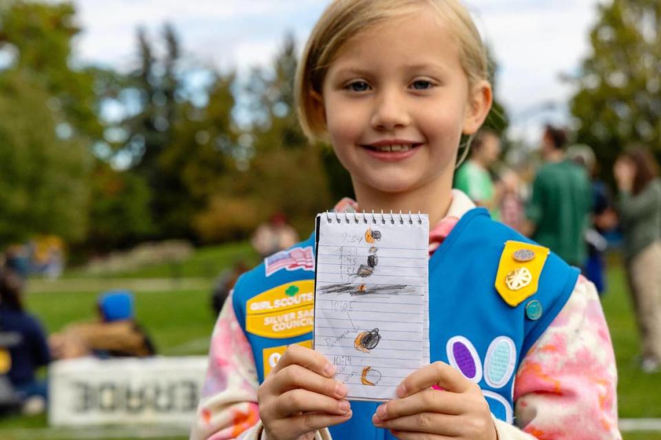 Dylan Watson, 7, of Boise, shows off a field journal she made while watching the annular solar eclipse at Boise State University, Saturday, Oct. 14, 2023. Watson tracked the time with drawings of the moon’s position in front of the sun with the help of her mother, Austin Watson.