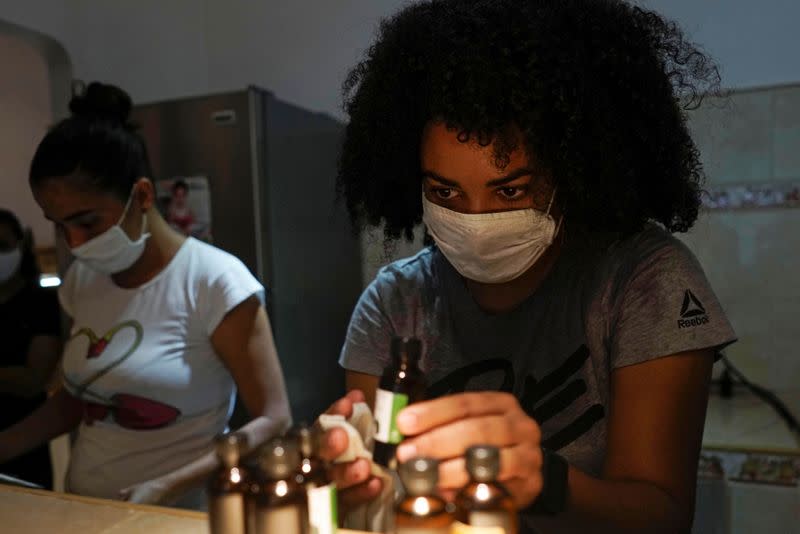 Sunei Pena (D) trabajando junto con sus colegas en una empresa de cosméticos orgánicos en La Habana, en medio de la pandemia de coronavirus