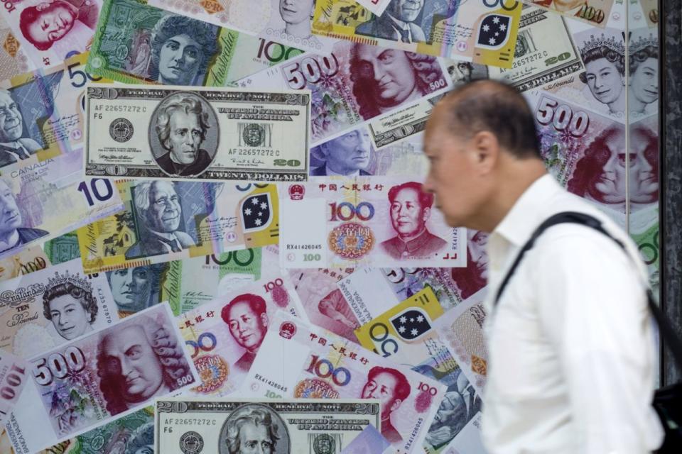 Un hombre camina delante de un anuncio que promociona servicios de cambio de renminbis (RMB) o yuanes chinos, dólares estadounidenses y euros en una casa de cambio de divisas extranjeras en Hong Kong, China (REUTERS / Tyrone Siu).