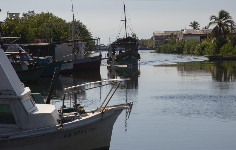 A boat arrives at the Surgidero de Batabano, where fishermen's boats dock in Batabano, Cuba, Tuesday, Oct. 25, 2022. Cuba is suffering from longer droughts, warmer waters, more intense storms, and higher sea levels because of climate change. (AP Photo/Ismael Francisco)