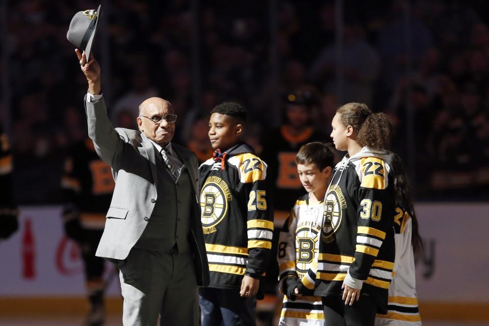 FILE - Hockey Hall of Famer Willie O'Ree, left, waves to the crowd before dropping the ceremonial puck before an NHL hockey game between the Boston Bruins and the Edmonton Oilers in Boston, Jan. 4, 2020. The first elite Indigenous hockey players played well before Willie O’Ree became the first Black player to skate in an NHL game in January 1958. (AP Photo/Michael Dwyer, File)