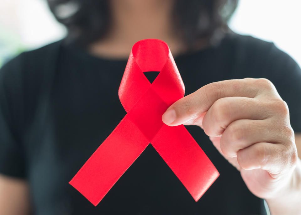 Aids red ribbon on woman's hand support for World aids day and national HIV/AIDS and aging awareness month concept