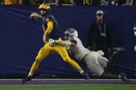 Michigan quarterback J.J. McCarthy (9) throws under pressure from TCU linebacker Dee Winters (13) during the second half of the Fiesta Bowl NCAA college football semifinal playoff game, Saturday, Dec. 31, 2022, in Glendale, Ariz. (AP Photo/Rick Scuteri)