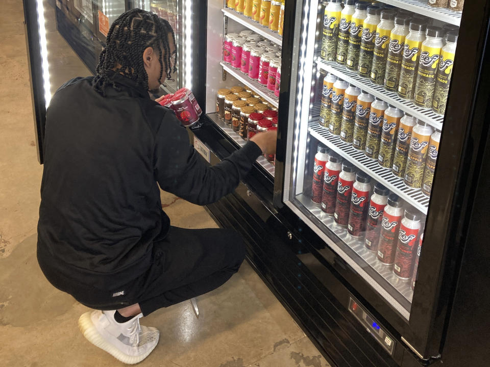 Ethan McKee, vice president of Mango Cannabis, arranges marijuana-infused soda inside a cooler at a medical dispensary, Tuesday, Feb. 28, 2023, in Oklahoma City. Voters in Oklahoma, which already has a robust medical marijuana program, will decide on Tuesday, March 7, whether to legalize cannabis for adults over the age of 21. (AP Photo by Sean Murphy)