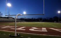 The lights shine on an empty football stadium at Richfield High School Wednesday night, April 8, 2020, in Richfield, Minn. Seeking to brighten spirits amid the virus outbreak, the symbolic act of turning on the lights became a movement — fueled by social media with the hashtag #BeTheLight — across the country. (AP Photo/Jim Mone)