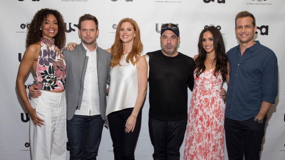 Gina Torres, Patrick J Adams, Sarah Rafferty, Rick Hoffman, Meghan Markle and Gabriel Macht standing in a line