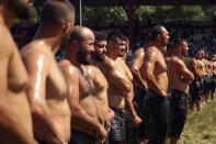 Wrestlers, doused in olive oil, are introduced to the crowds during the 660th instalment of the annual Historic Kirkpinar Oil Wrestling championship, in Edirne, northwestern Turkey, Saturday, July 10, 2021.Thousands of Turkish wrestling fans flocked to the country's Greek border province to watch the championship of the sport that dates to the 14th century, after last year's contest was cancelled due to the coronavirus pandemic. The festival, one of the world's oldest wrestling events, was listed as an intangible cultural heritage event by UNESCO in 2010. (AP Photo/Emrah Gurel)