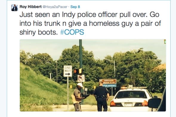 Police officer hands homeless man new boots