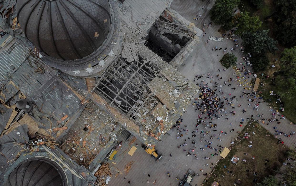 Believers gathered next to the Transfiguration Cathedral, which was damaged by Russian missile strikes on Sunday (REUTERS)