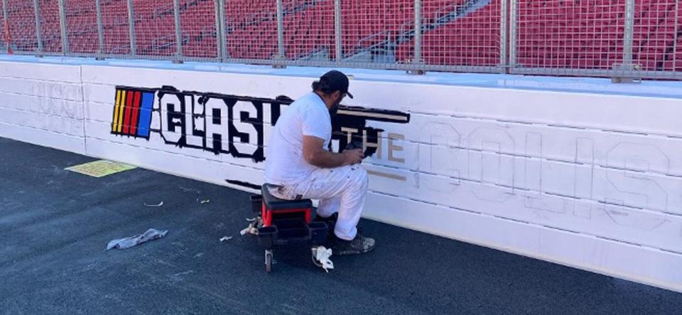 A painter prepares the outer wall for the Busch Light Clash at the LA Coliseum.