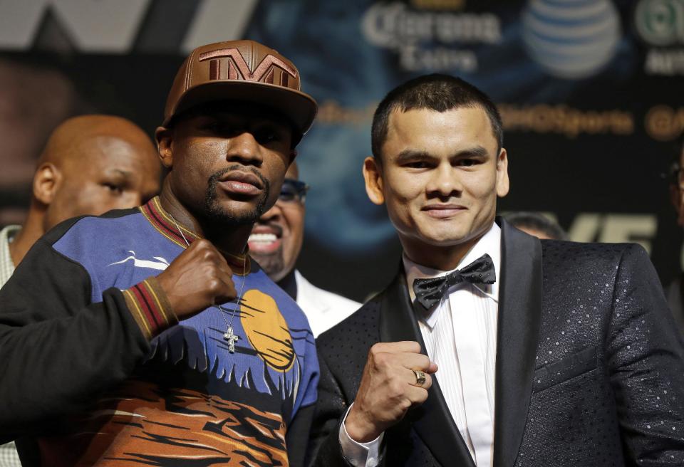 Floyd Mayweather Jr., left, and Marcos Maidana pose for photos during a news conference Wednesday, April 30, 2014, in Las Vegas. The pair square off in a welterweight title fight on Saturday, May 3. (AP Photo/Isaac Brekken)