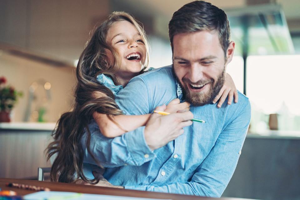 father and daughter having fun at home and laughing at jokes
