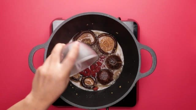 Adding goji berries to pot of mushrooms