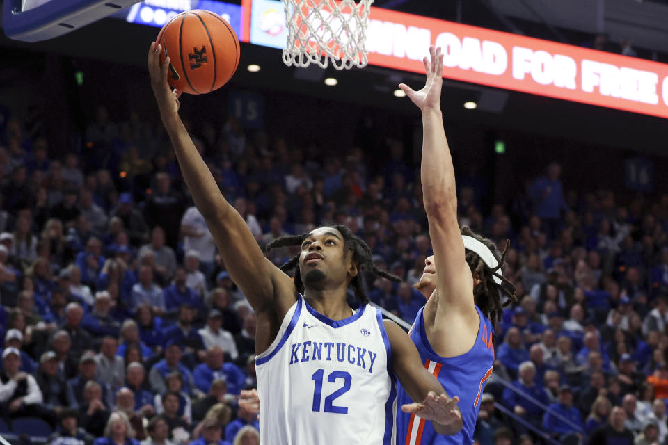 Kentucky's Antonio Reeves (12) shoots while pressured by Florida's Walter Clayton Jr. during the second half of an NCAA college basketball game Wednesday, Jan. 31, 2024, in Lexington, Ky. (AP Photo/James Crisp)