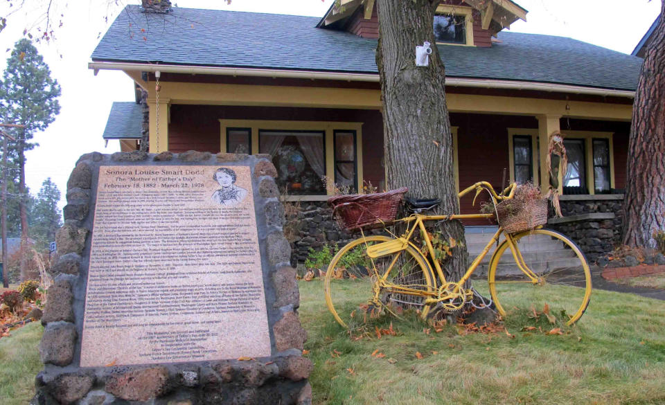 FILE - A sign stands on Nov. 21, 2014, outside the home where Sonora Smart Dodd lived in Spokane, Wash., in the early 20th century. The sign commemorates Dodd as the person who conceived the idea of Father's Day in 1909, the so-called ''Mother of Father's Day.'' The Craftsman-style house is privately owned and occupied, but the marker telling the story of the local connection to the holiday's history can be seen in the front yard. (AP Photo/Nicholas K. Geranios, File)