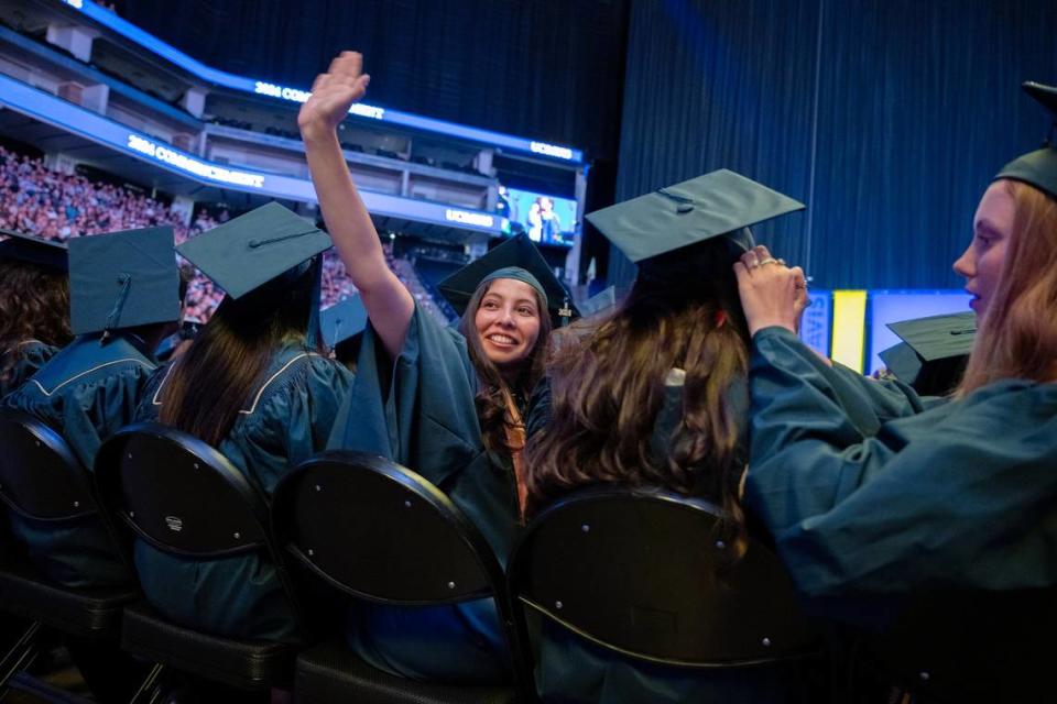 Marisabel Munoz Chavez waves to supporters sitting in the stands in the Golden 1 Center as the 2024 graduating class of UC Davis received their diplomas on Friday.