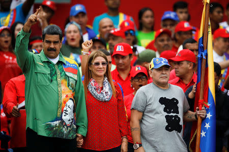 Venezuela's President Nicolas Maduro, his wife Cilia Flores and former Argentinian soccer player Diego Armando Maradona greet supporters during a campaign rally in Caracas, Venezuela May 17, 2018. REUTERS/Carlos Garcia Rawlins